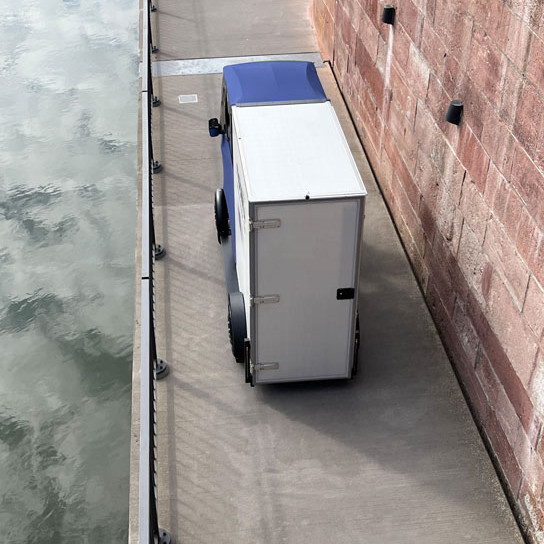 Antric Cargobike fährt auf einem schmalen Fußgängerweg an einem Fluß entlang